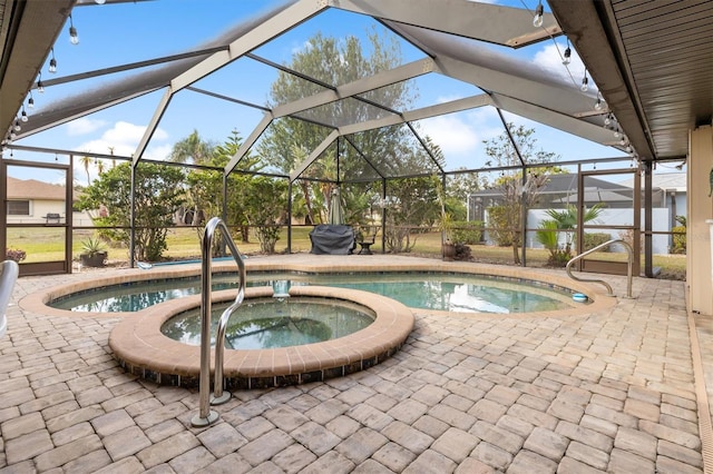 view of pool featuring an in ground hot tub, a patio area, and glass enclosure