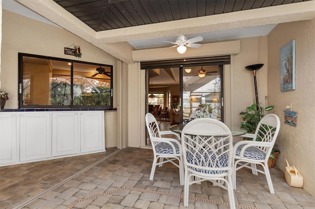 sunroom / solarium featuring ceiling fan and beam ceiling