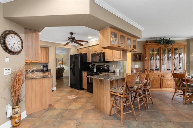 kitchen with a kitchen bar, ornamental molding, kitchen peninsula, dark stone counters, and black appliances