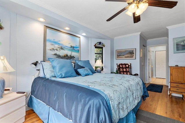 bedroom with crown molding, ceiling fan, and light hardwood / wood-style floors