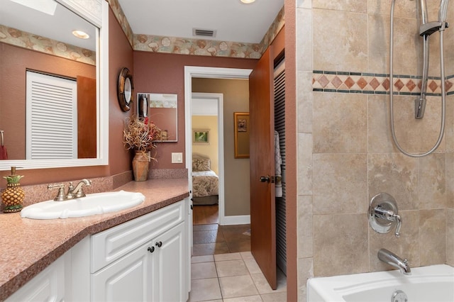 bathroom featuring tiled shower / bath, vanity, and tile patterned floors