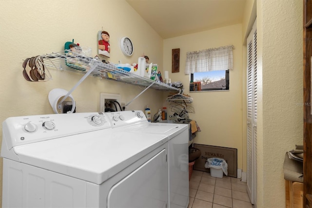 laundry area featuring washer and dryer and light tile patterned flooring