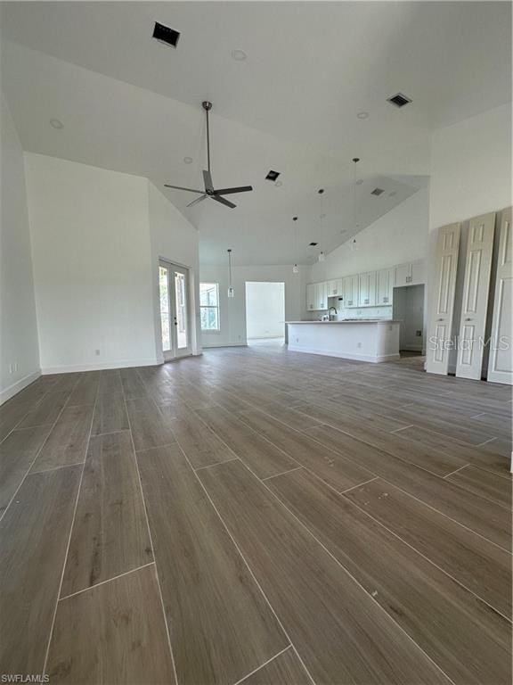 unfurnished living room featuring french doors, ceiling fan, and lofted ceiling