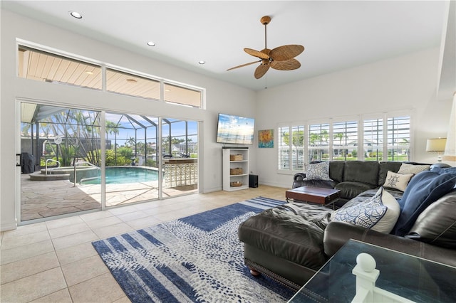 living room featuring light tile patterned flooring, a towering ceiling, and ceiling fan