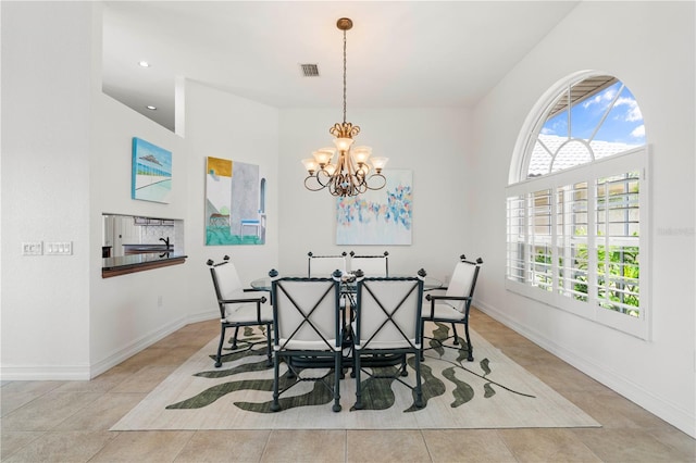 tiled dining space featuring plenty of natural light and an inviting chandelier