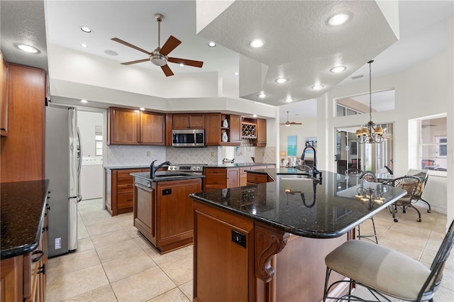 kitchen featuring a large island, sink, pendant lighting, a breakfast bar, and stainless steel appliances