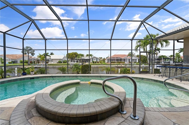 view of pool featuring an in ground hot tub, a water view, and a lanai