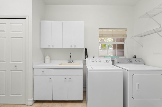 laundry area with cabinets, sink, washing machine and dryer, and light tile patterned floors