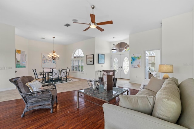 living room with hardwood / wood-style floors and ceiling fan with notable chandelier