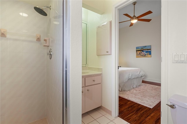 bathroom with vanity, hardwood / wood-style flooring, ceiling fan, and a tile shower