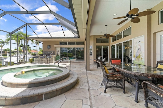 view of patio / terrace with an in ground hot tub, ceiling fan, and a lanai