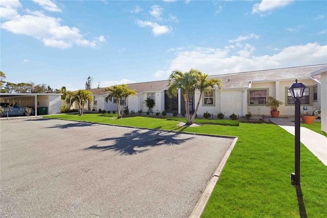 single story home with a front lawn and a carport