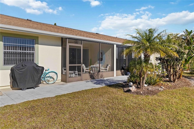 rear view of house featuring a sunroom and a lawn