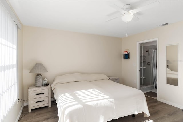 bedroom featuring dark wood-type flooring, ceiling fan, connected bathroom, and a spacious closet