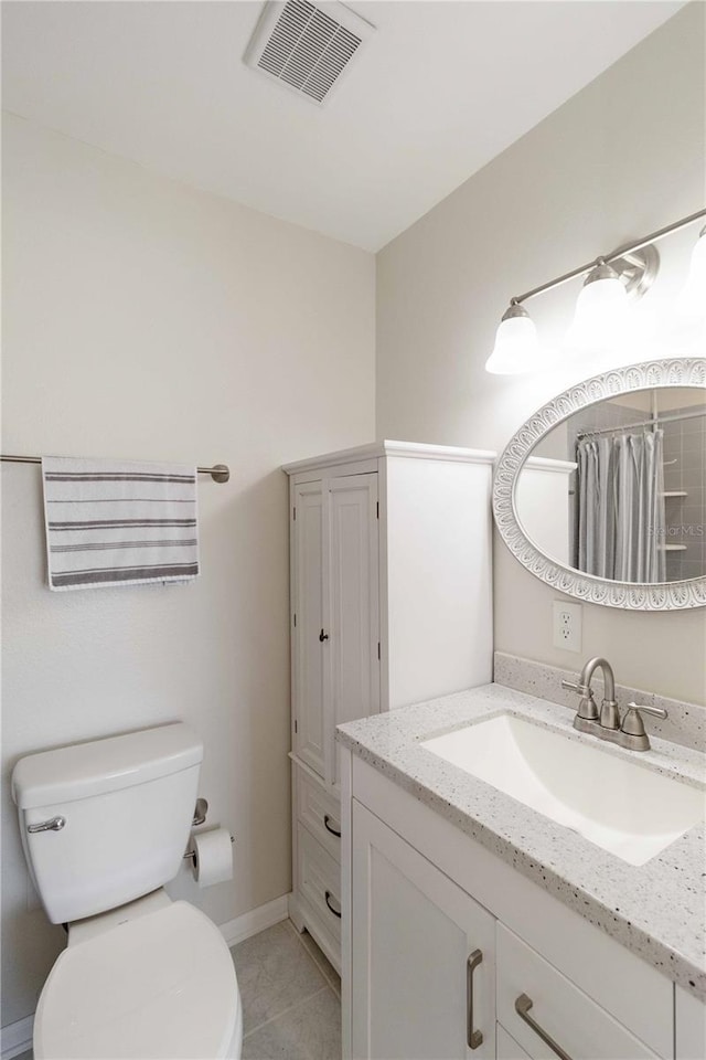 bathroom with tile patterned flooring, vanity, toilet, and walk in shower