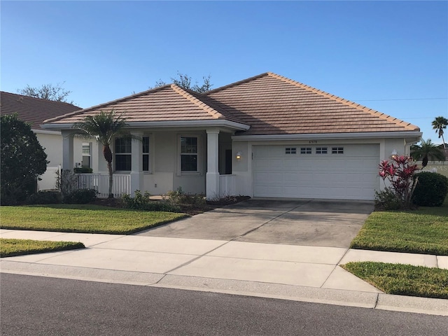 ranch-style home with a garage, a front lawn, and a porch