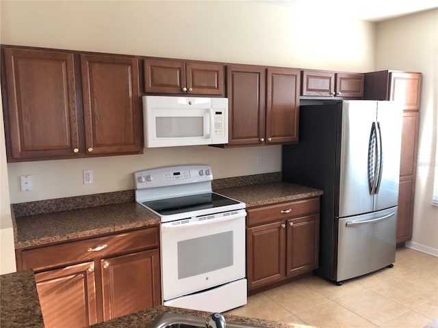 kitchen with light tile patterned flooring and white appliances