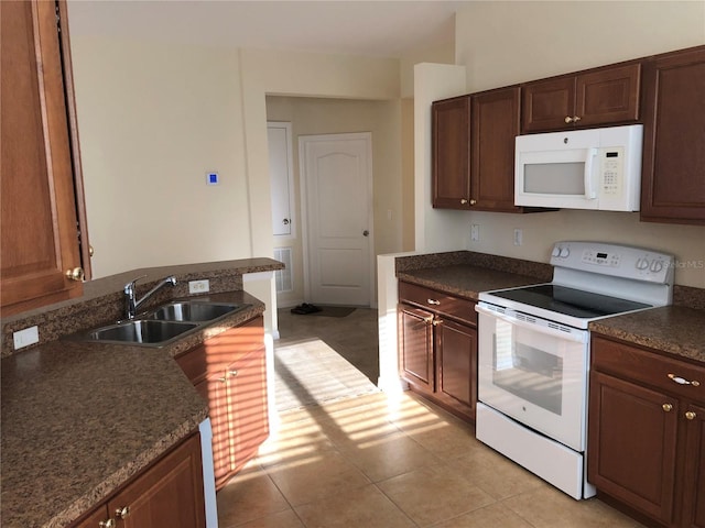 kitchen featuring sink, light tile patterned floors, and white appliances