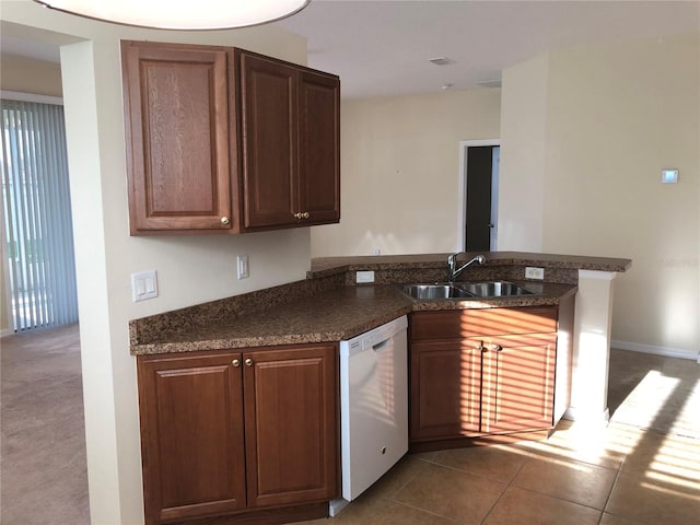 kitchen featuring light tile patterned flooring, white dishwasher, kitchen peninsula, and sink