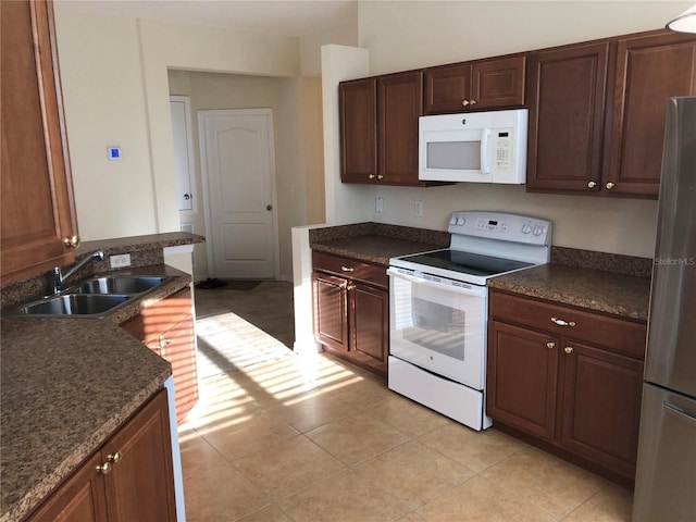 kitchen with sink, light tile patterned floors, and white appliances