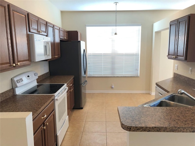 kitchen with sink, dark brown cabinets, light tile patterned floors, pendant lighting, and white appliances