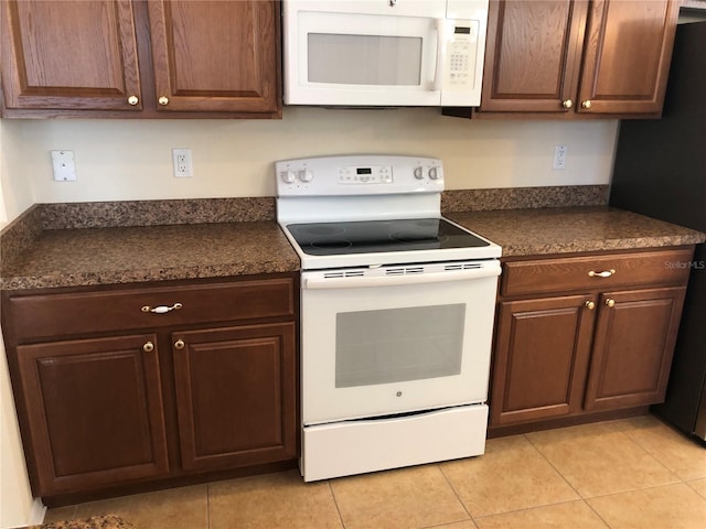 kitchen with light tile patterned floors and white appliances