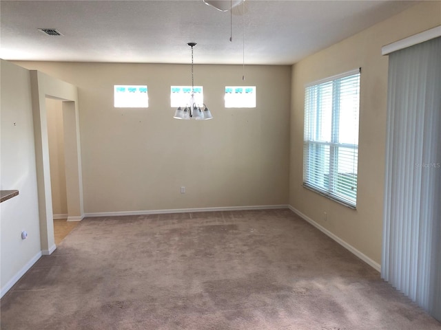 unfurnished dining area featuring carpet flooring and an inviting chandelier