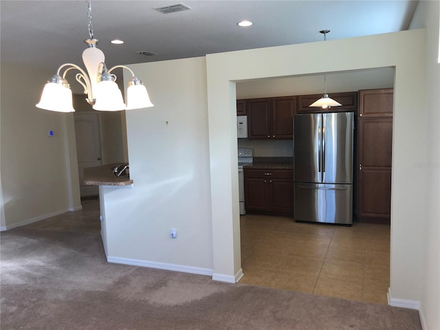 kitchen featuring light carpet, white appliances, pendant lighting, and dark brown cabinetry