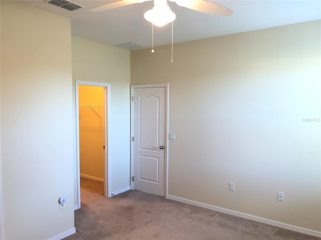 carpeted spare room featuring ceiling fan