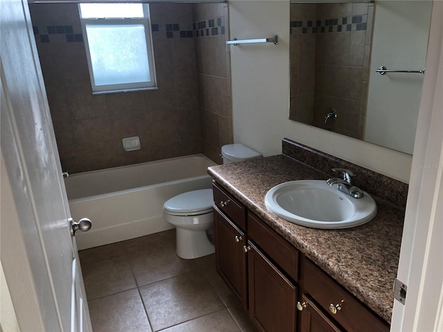 full bathroom with tile patterned flooring, vanity, tiled shower / bath, and toilet