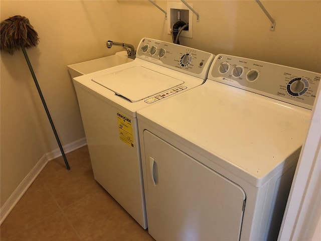 laundry area with light tile patterned floors and washer and dryer