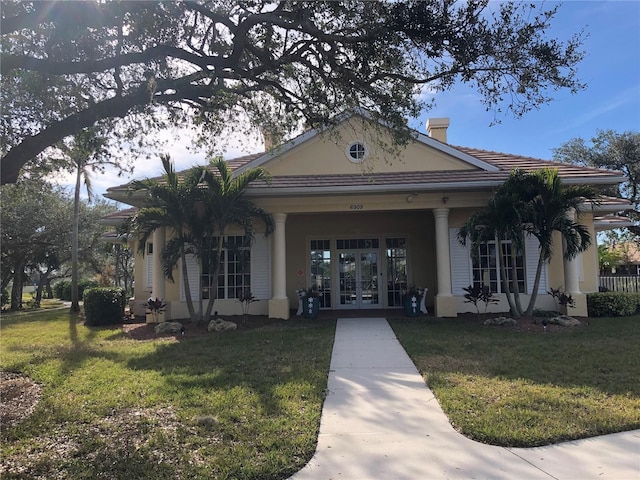 view of front facade with a front yard and french doors