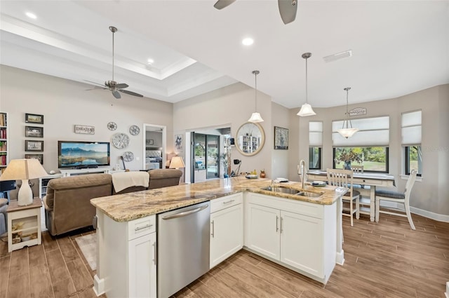 kitchen with sink, hanging light fixtures, dishwasher, light stone countertops, and white cabinets