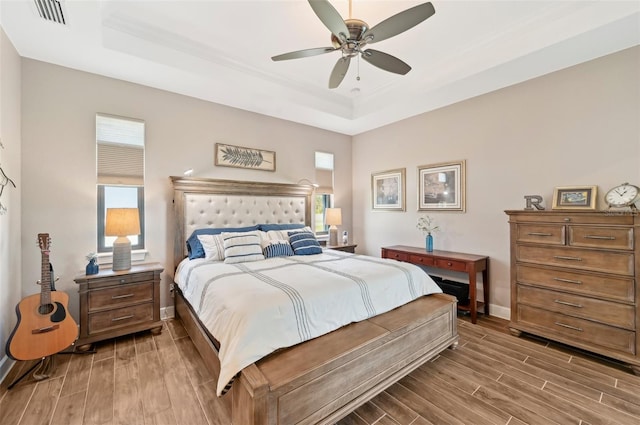 bedroom with a raised ceiling and ceiling fan