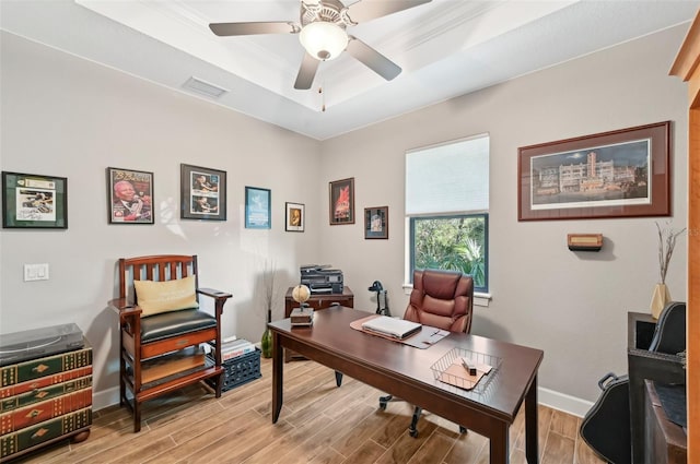 office with ceiling fan, a raised ceiling, and light hardwood / wood-style flooring