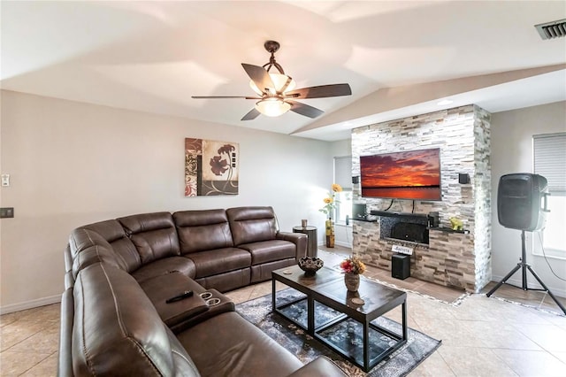 tiled living room featuring ceiling fan, a fireplace, and vaulted ceiling