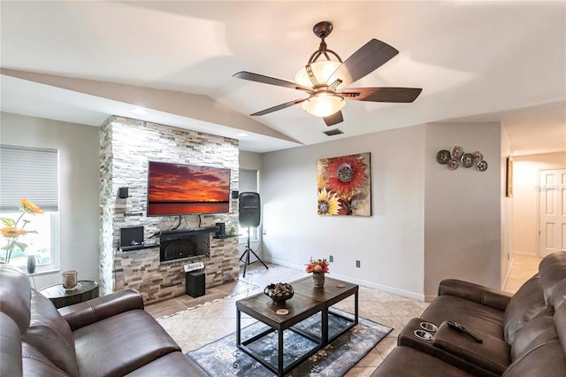 tiled living room featuring ceiling fan, lofted ceiling, and a fireplace