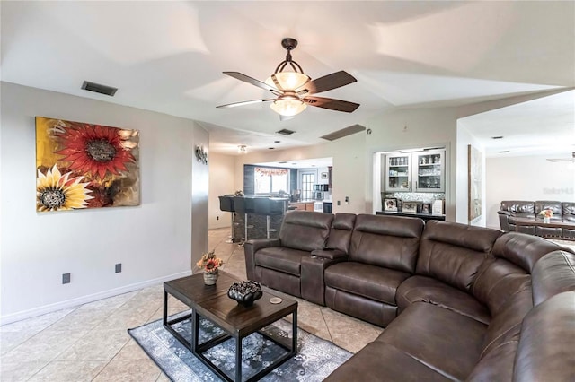 living room featuring ceiling fan, lofted ceiling, and light tile patterned floors