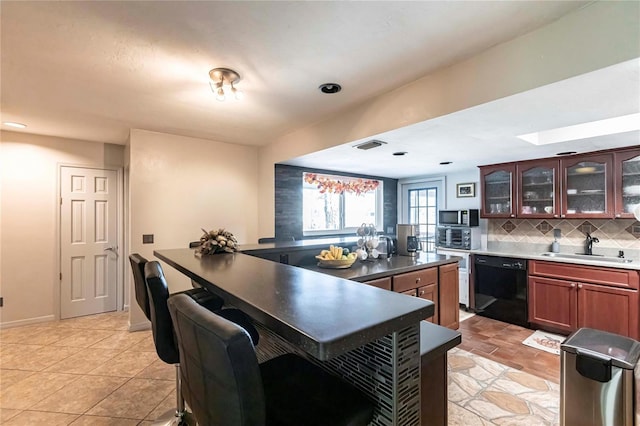 kitchen with light tile patterned floors, sink, backsplash, a center island, and black dishwasher