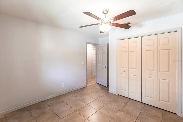 unfurnished bedroom with ceiling fan, a closet, and light tile patterned floors