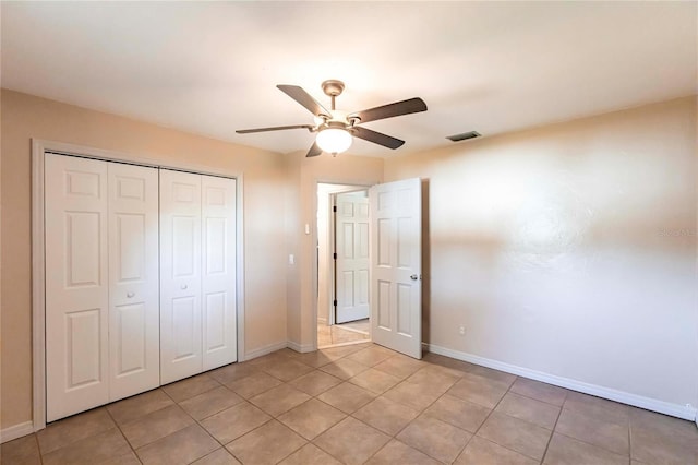 unfurnished bedroom featuring light tile patterned flooring, ceiling fan, and a closet