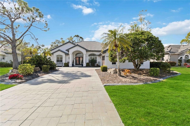 mediterranean / spanish-style home featuring a front lawn