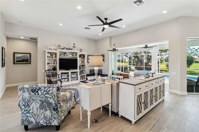 living room featuring ceiling fan and light hardwood / wood-style floors