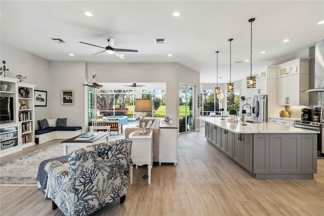 living room with ceiling fan and light wood-type flooring