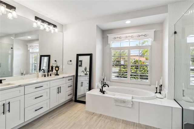 bathroom with vanity, separate shower and tub, and wood-type flooring