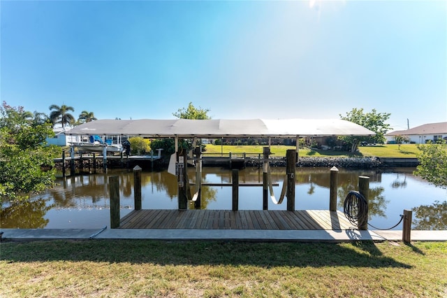 dock area with a lawn and a water view