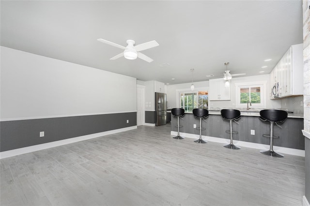 kitchen with a kitchen breakfast bar, kitchen peninsula, and white cabinets