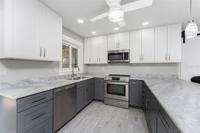 kitchen featuring gray cabinets, appliances with stainless steel finishes, sink, and white cabinets