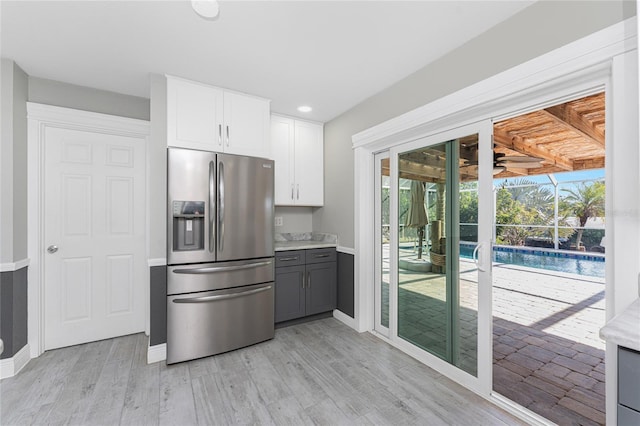 kitchen with stainless steel refrigerator with ice dispenser, white cabinetry, light hardwood / wood-style flooring, and gray cabinetry