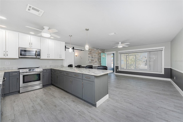 kitchen with white cabinetry, stainless steel appliances, gray cabinets, and kitchen peninsula